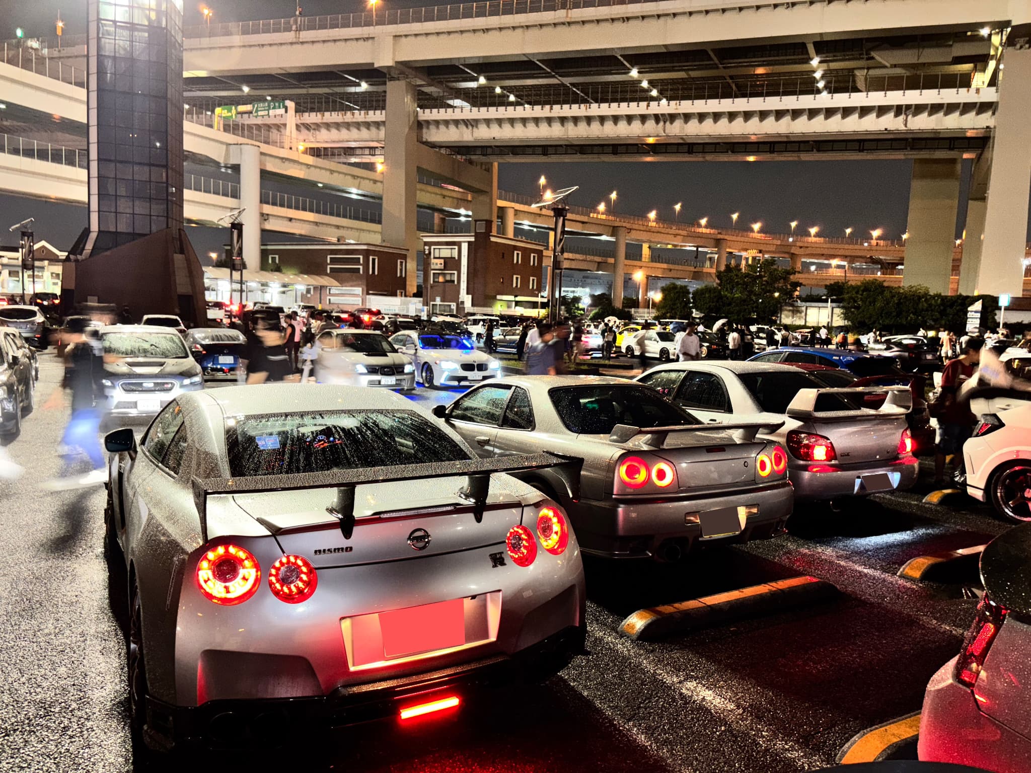 Three iconic JDM rental cars Skyline HR34, Skyline ER34, and GT-R R35 lined up in Tokyo at night