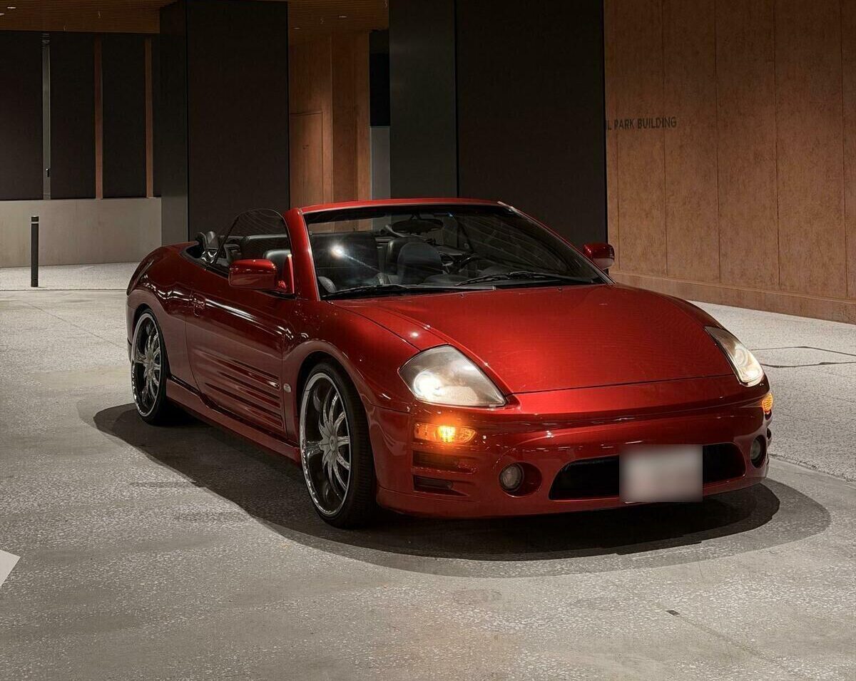 Candy red Mitsubishi Eclipse Spyder convertible at night