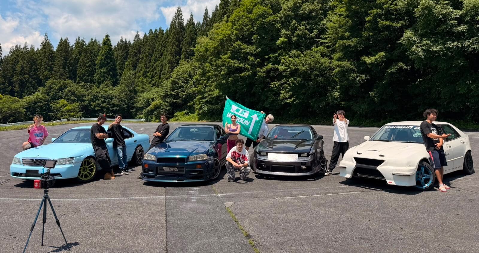 Group photo of the complete Wangun OG JDM performance car fleet gathered at night in Tokyo
